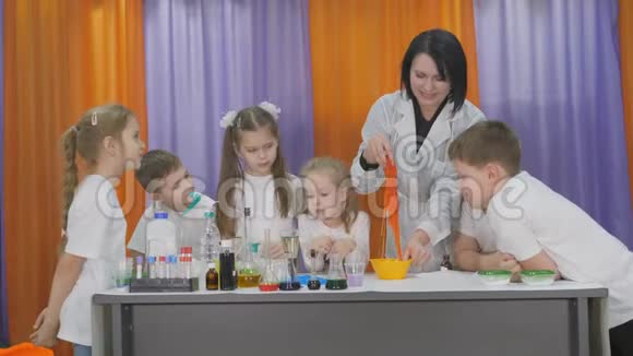 儿童化学实验老师把弹性混合物搅拌在黄色的碗里房间满了视频的预览图