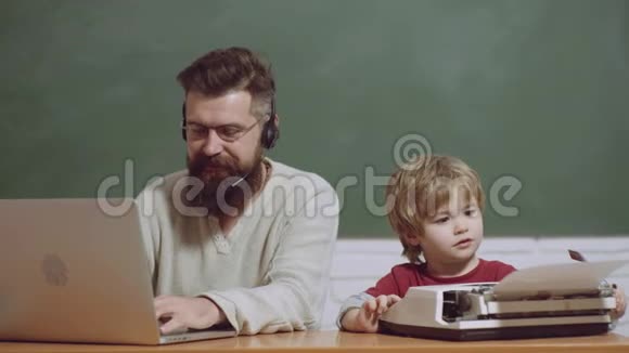 一代人几代人的年龄父亲和儿子在打字机和笔记本电脑上打字老年人和年轻人技术视频的预览图