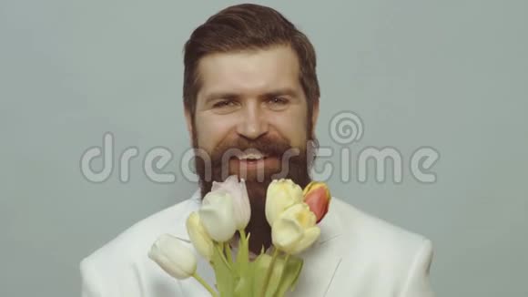 手捧郁金香花束的人春天三月八日快乐和相爱情人节一个男人躲在一束花后面视频的预览图
