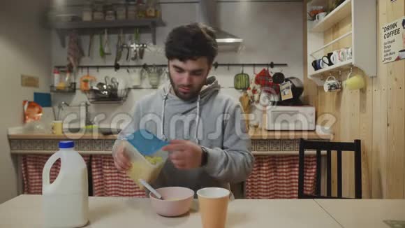 一个在厨房吃早餐的年轻人男人吃玉米片视频的预览图