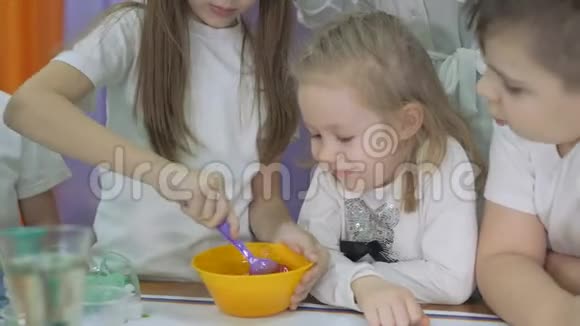 儿童化学实验幼儿将配料加入黄色碗中搅拌房间里满是人造的视频的预览图