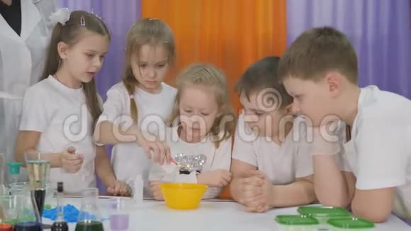 儿童化学实验幼儿将试剂倒入黄色的碗中房间里弥漫着人造烟雾视频的预览图