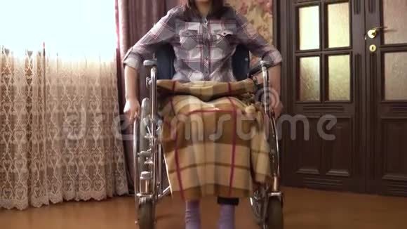 坐轮椅的年轻女子女孩坐轮椅在房子周围走动女孩正在接近摄像机视频的预览图