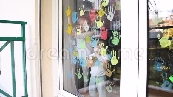 孩子们用手掌在窗户上画画检疫视频的预览图