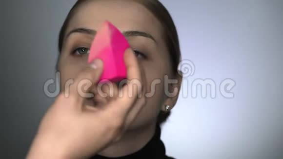 化妆师在美容工作室为年轻女性做专业化妆化妆师用特制海绵视频的预览图