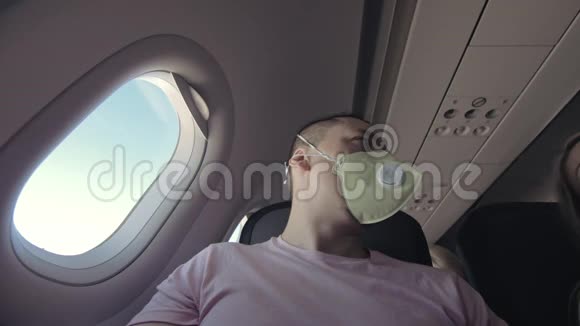 人类在飞机上旅行白种人戴着防护医疗面罩防护呼吸器飞机男性游客视频的预览图