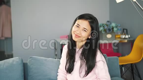 欢快迷人的亚洲女孩微笑着看镜头的肖像视频的预览图