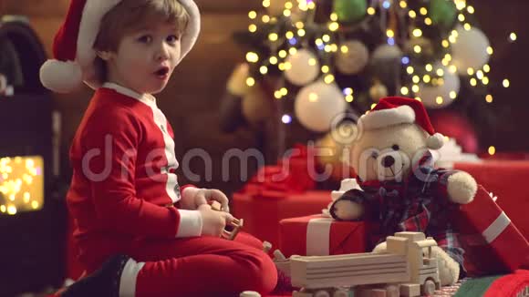 冬季圣诞节孩子们的情感新年孩子可爱的孩子玩圣诞礼物圣诞老人帽子上的可爱孩子视频的预览图