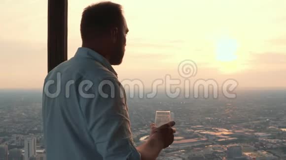 英俊的男人喝着鸡尾酒从摩天大楼俯瞰美国芝加哥的全景视频的预览图