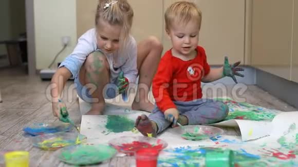 可爱可爱的白种人金发碧眼的小兄弟姐妹孩子们喜欢和妈妈一起玩画笔和手掌视频的预览图