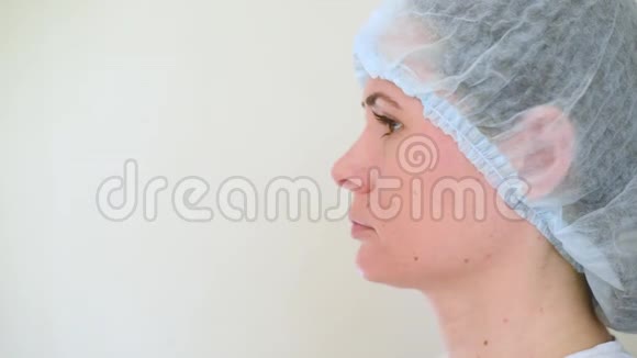 年轻的女医生在白色背景上戴上一个医疗面具外科手术室冠状病毒covid19covid19视频的预览图