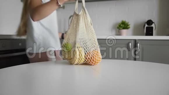 零废家和生态袋生态购物可重复使用的购物袋厨房上的水果放在木桌上视频的预览图