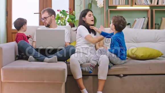 有趣的是在家里年轻的一家人和两个小孩子一起坐在沙发上玩玩得很开心视频的预览图