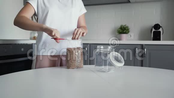 女人把荞麦倒入一个玻璃罐子里储存视频的预览图