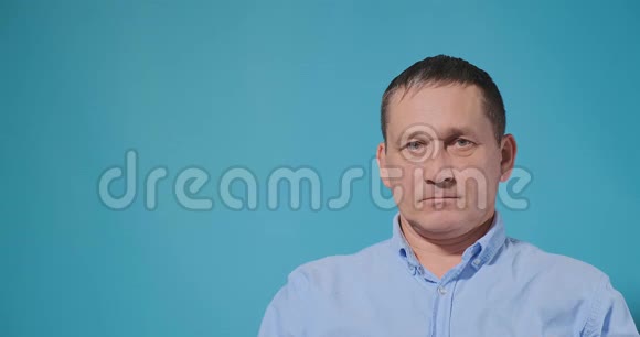 穿蓝色衬衫的男人咳嗽戴上白色一次性口罩视频的预览图