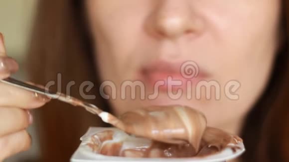 用勺子夹着吃干酪的女人女口吃乳制品酸奶加巧克力早餐视频的预览图