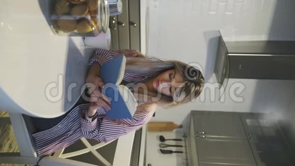 一个年轻漂亮的黑发女人头发松松戴眼镜在家里喝咖啡看书视频的预览图