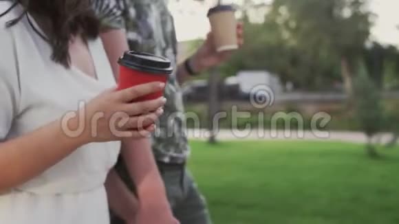 一对年轻可爱的夫妇在夏季公园散步喝咖啡聊天视频的预览图