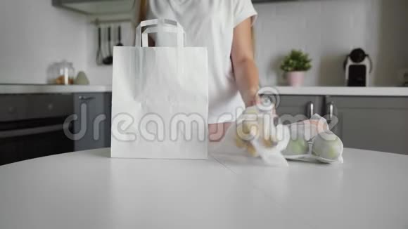 年轻女子在木桌上的厨房里用水果包装纸购物袋零废家和生态袋生态视频的预览图