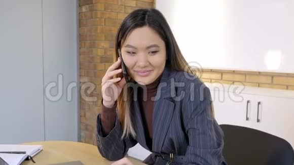 一个亚洲女人在智能手机上说话的肖像视频的预览图