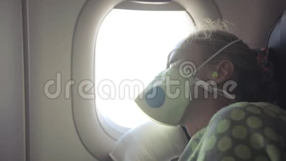 女人在飞机上旅行白种人戴着防护医疗面罩带呼吸器的飞机上的女游客感觉不好视频的预览图