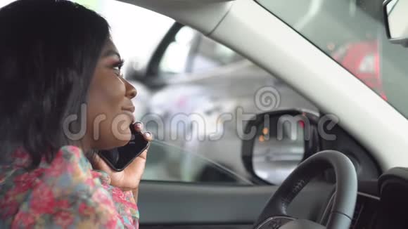 非裔美国女商人坐在车里打电话车是白色的视频的预览图