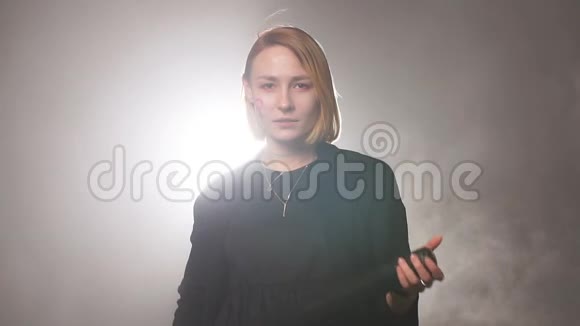 年轻的高加索女性女权主义者站在烟雾弥漫的空间里手持蝙蝠视频的预览图