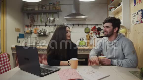 微笑的夫妇在厨房喝咖啡快乐的男人和女人说话视频的预览图
