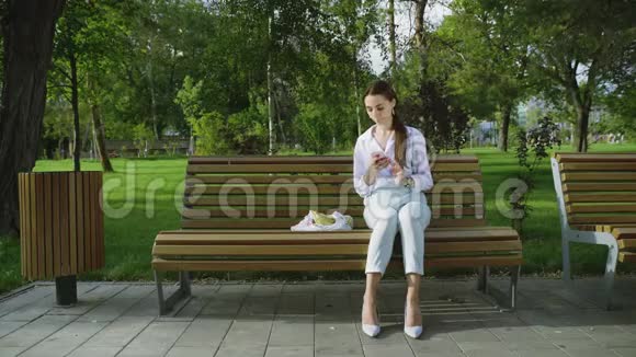 在夏天的公园里年轻的女人坐在长凳上手里拿着装满水果和蔬菜的棉网购物袋零废物视频的预览图