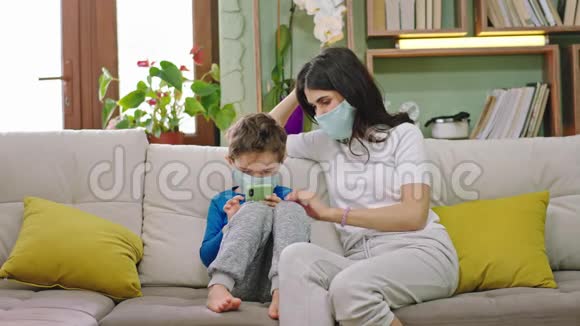 在家隔离的时间年轻的母亲和她的孩子坐在沙发上她加快了和她的孩子在一起的时间而他视频的预览图