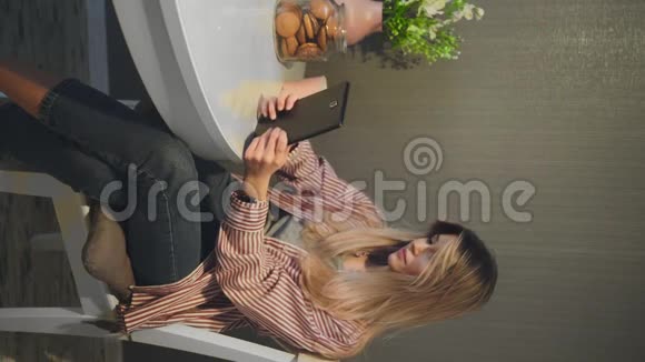 厨房里使用数字平板电脑的迷人女人的垂直视频视频的预览图