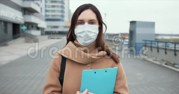 疫控制工白种人社会护理妇女在检疫期间空街戴医疗面罩的肖像视频的预览图