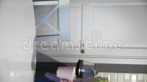 年轻美丽的黑发女人在厨房的家里倒咖啡的垂直视频视频的预览图