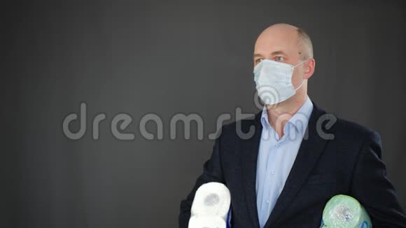 成熟的商人戴着面具拿着卫生纸戴防护罩的人把卫生纸卷起来视频的预览图
