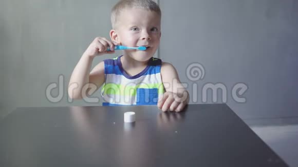 男孩在浴缸里刷牙微笑浅灰色背景视频的预览图