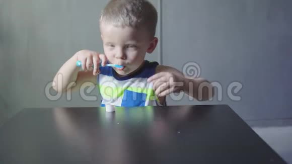 男孩在浴缸里刷牙微笑浅灰色背景视频的预览图