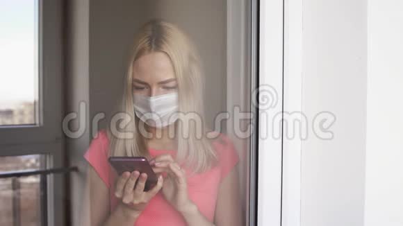 戴着面具的漂亮女孩正孤立地站在房子的窗户前视频的预览图
