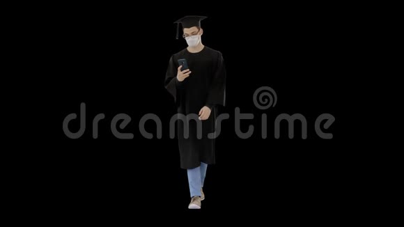 戴着毕业礼服戴着医疗面具的年轻人使用智能手机阿尔法频道视频的预览图