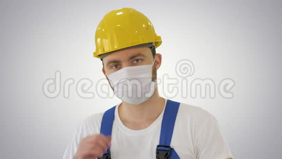 戴上面具戴着面具的建筑工人在梯度背景下视频的预览图