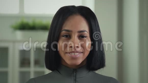 一位美丽的非裔美国妇女对着镜头微笑的肖像视频的预览图