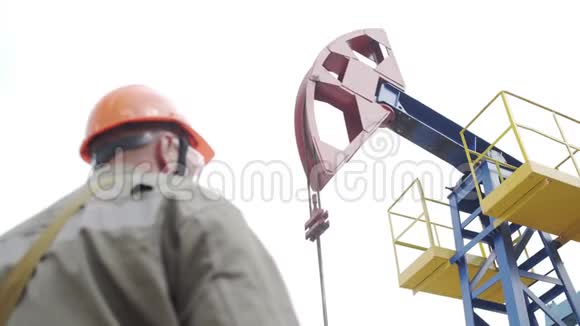 原油生产现场监督抽油机的男工程师剪影工业油泵千斤顶工作视频的预览图