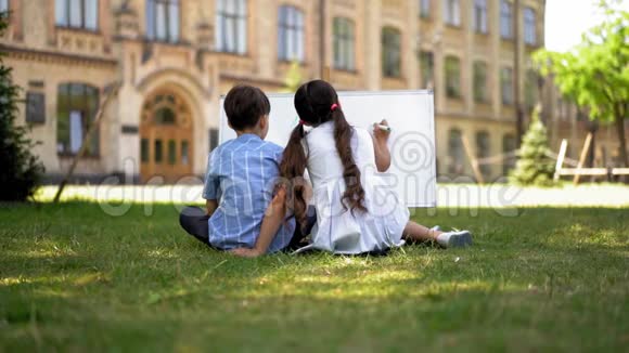 男孩和女孩用白板在学校院子里学习视频的预览图
