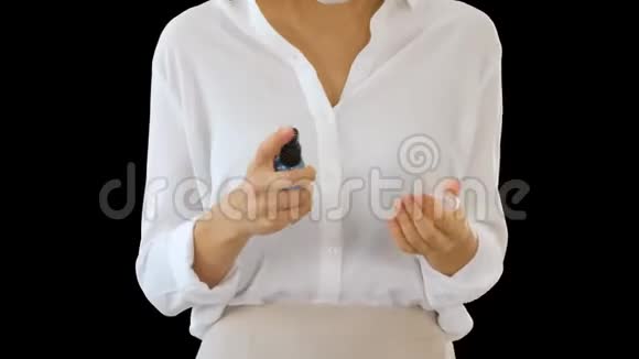 年轻女性在行走时使用皮肤消毒器保护双手免受任何病毒感染阿尔法频道视频的预览图