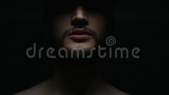 黑色背景上说话的男性嘴的深色特写肖像视频的预览图