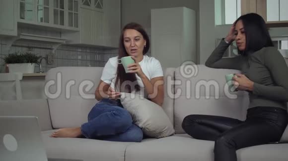 漂亮的年轻女孩在沙发上聊天视频的预览图