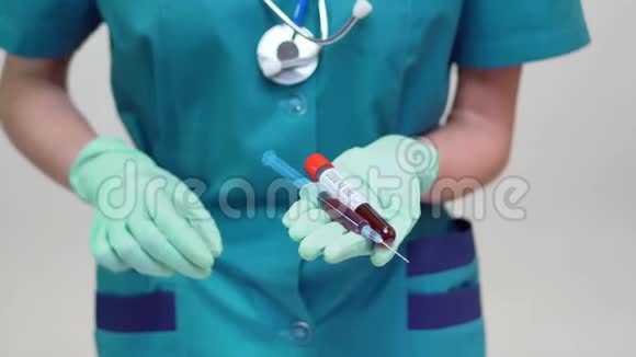 戴防护面罩和乳胶手套的护士医生持血试管和注射器视频的预览图