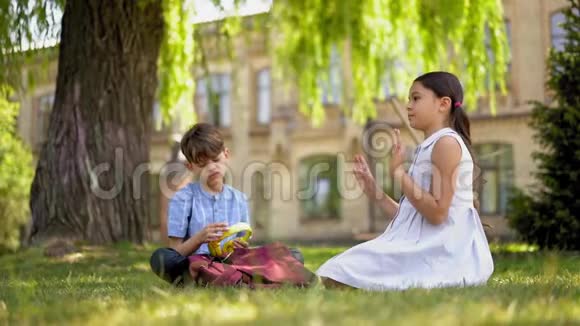 男孩听音乐女孩坐在草坪上跳舞视频的预览图
