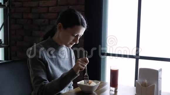 在咖啡馆里吃饭的年轻美女健康食品沙拉和果汁视频的预览图