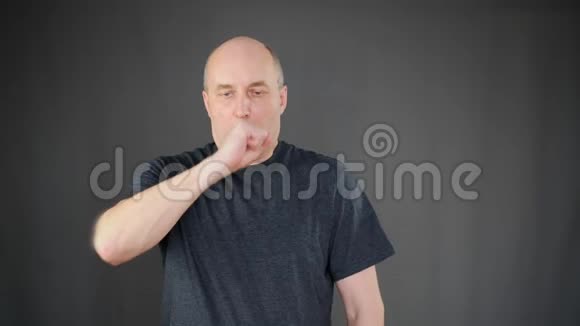 生病的成熟男人咳嗽时用拳头捂住嘴视频的预览图