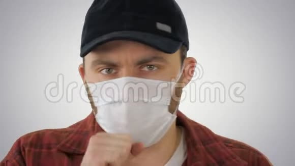 戴着医用面具的美国农民在梯度背景下咳嗽视频的预览图